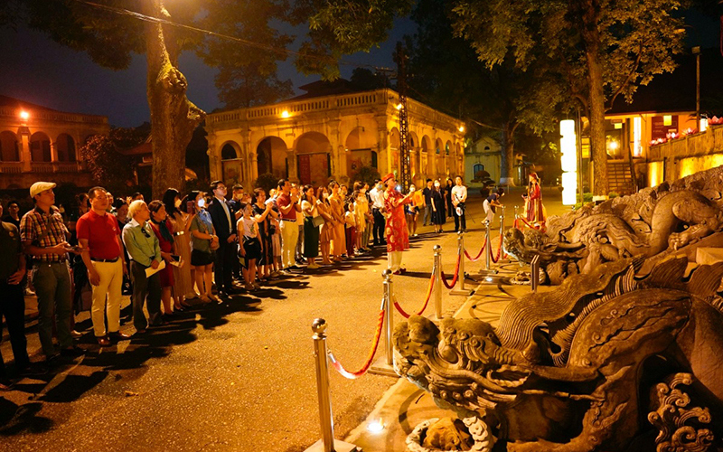 Khách du lịch dâng hương trước thềm điện Kính Thiên trong tua đêm Giải mã Hoàng thành Thăng Long.