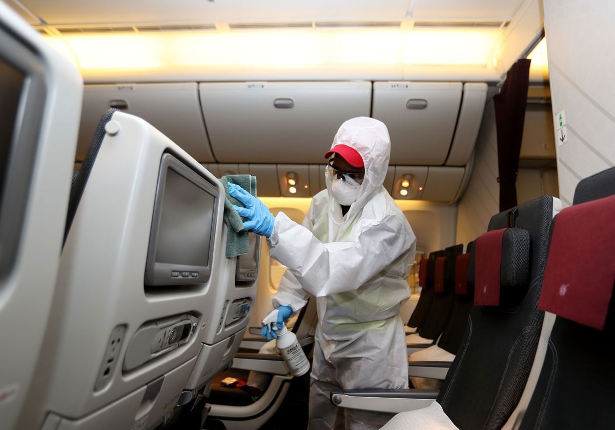 Nhân viên một hãng hàng không khử trùng ghế ngồi trên máy bay nhằm ngăn sự lây lan của Covid-19. Nguồn: AFP.