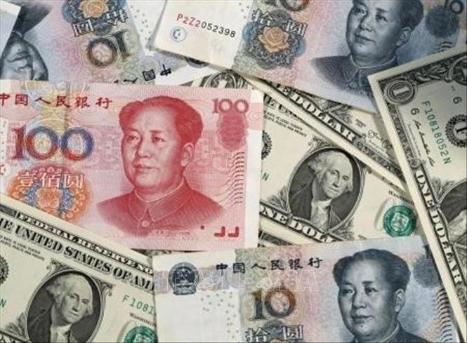 Đồng NDT của Trung Quốc và đồng USD. Nguồn: Kyodo/TTXVN