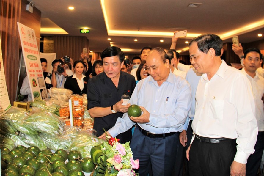 Thủ tướng Chính phủ Nguyễn Xuân Phúc đi thăm một gian hàng nông sản của một doanh nghiệp ở Đắk Lắk.