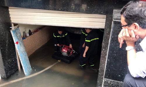 Máy bơm được đưa xuống hầm để bơm nước ra, cứu hộ ôtô và xe máy đang bị ngập tại tòa nhà ở quận 5, TP Hồ Chí Minh. Nguồn: vnexpress.net