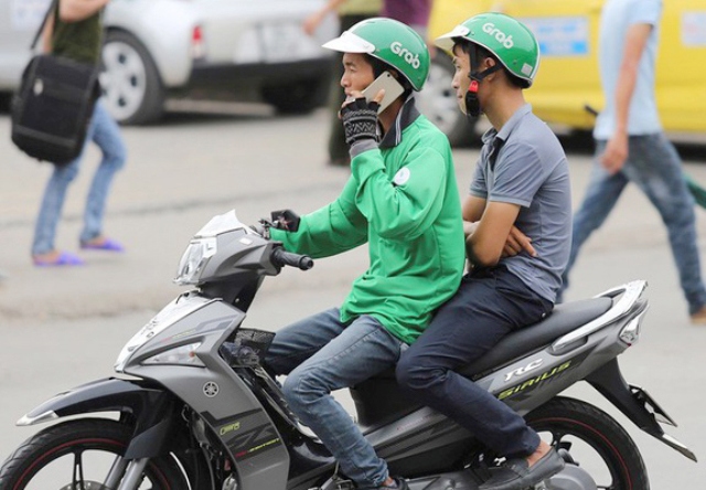  Ngày càng xuất hiện nhiều tình trạng lái xe mô tô grap vừa đi vừa gọi điện thoại di động. Nguồn: Kinh tế và Dự báo