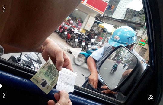 Nhân viên trật tự đô thị quận 5 vẫn thu phí hộ dù Sở GTVT TP. Hồ Chí Minh đã nghiêm cấm. (Ảnh chụp ngày 28-8). Nguồn: nld.vn
