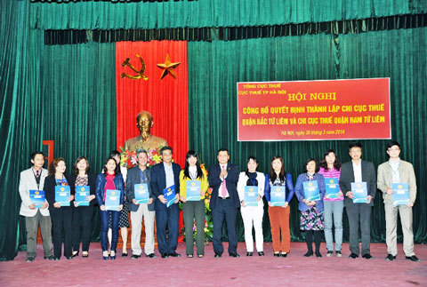 Cục trưởng Cục thuế Hà Nội trao các quyết định chức danh giữ chức vụ lãnh đạo chi cục thuế của hai quận mới. Nguồn: thoibaotaichinhvietnam.vn