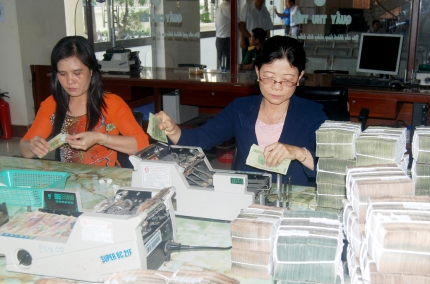 Cán bộ, nhân viên Phòng Kho quỹ kiểm tra tiền trước khi nhập kho. Nguồn: baocamau.com.vn