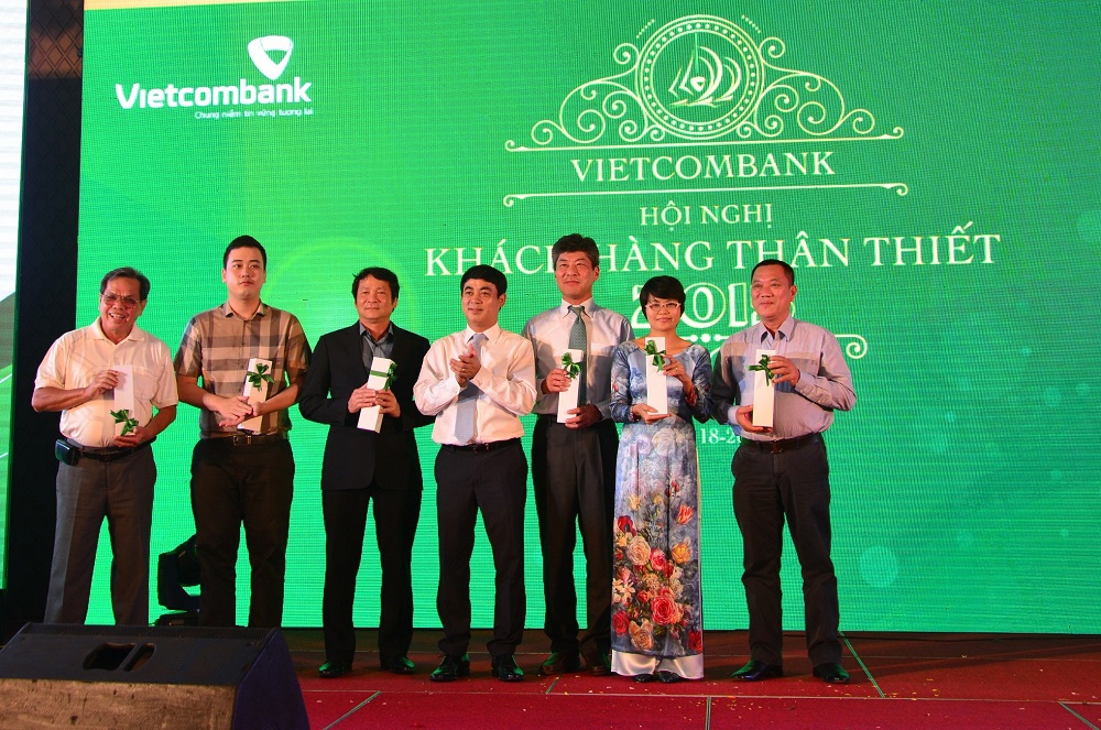 Ông Nghiêm Xuân Thành - Chủ tịch Hội đồng quản trị Vietcombank(đứng giữa) tặng quà tri ân cho khách hàng thân thiết của Vietcombank.