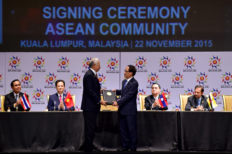 Thủ tướng Malaysia Najib Tun Abdul Razak trao các văn kiện liên quan về việc thành lập Cộng đồng ASEAN cho Tổng Thư ký ASEAN Lê Lương Minh. Ảnh: VGP/Nhật Bắc 