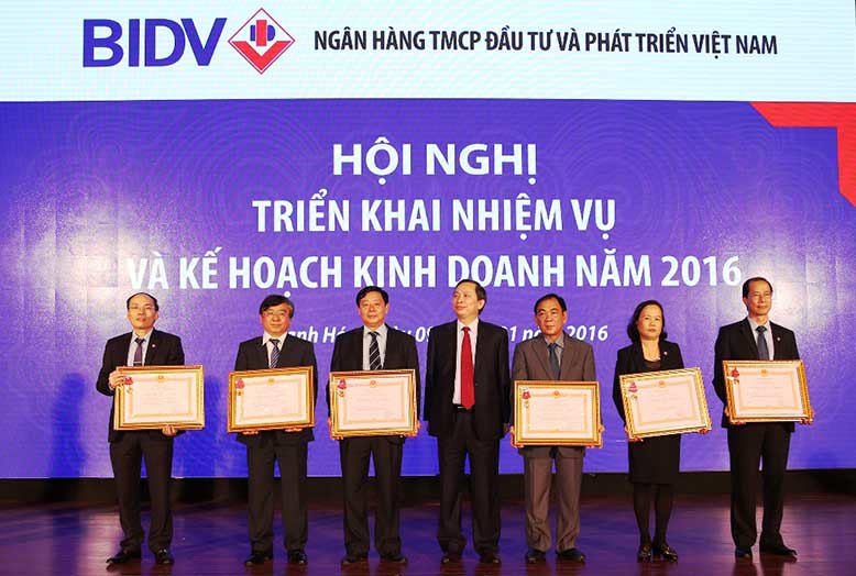 Phó Thống đốc NHNN Việt Nam Đào Minh Tú  trao bằng khen cho các cá nhân của BIDV đạt nhiều thành tích trong năm 2015. Ảnh: VGP