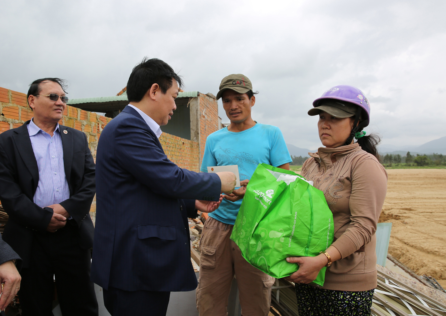 Phó Thủ tướng Vương Đình Huệ tặng quà cho gia đình anh Đào Anh Phước và một số hộ dân khác bị sập nhà do vỡ đê sông Kôn. Ảnh: VGP/Thành Chung.