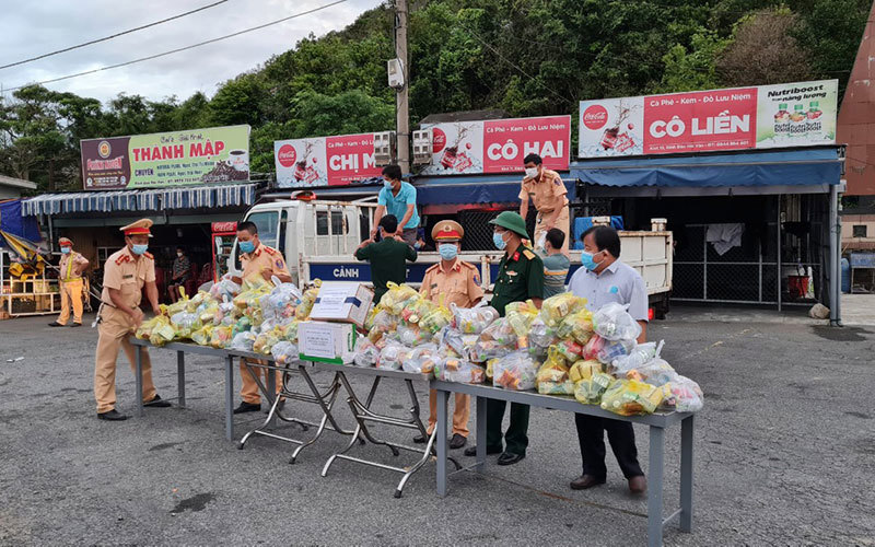 Cảnh sát giao thông Thừa Thiên Huế cùng các ban, ngành huyện Phú Lộc tiếp tế lương thực, nước uống cho người dân từ TP Hồ Chí Minh tại chốt kiểm soát y tế. 