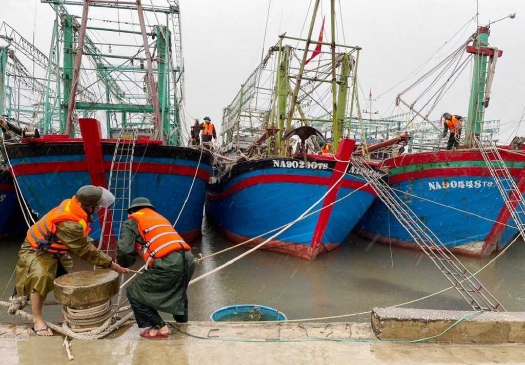 Lực lượng chức năng giúp các chủ tàu cá neo đậu, chằng chống tàu thuyền. Ảnh: Chinhphu.vn