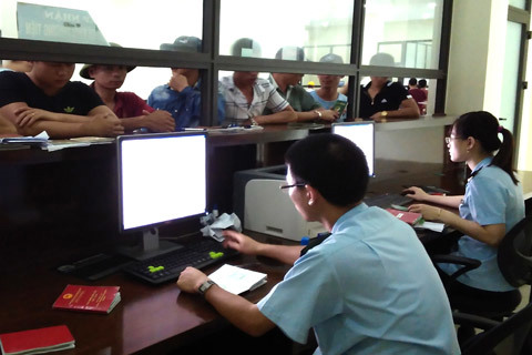 Cán bộ Chi cục Hải quan Cha Lo giải quyết thủ tục xuất nhập cảnh cho người dân sau đợt mưa lũ. Nguồn: PV.