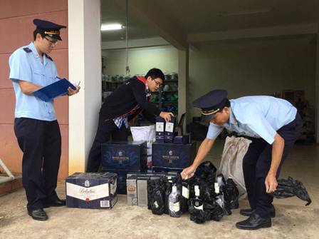Cán bộ Hải quan Quảng Trị kiểm tra lô hàng rượu nhập ngoại. Nguồn: PV.