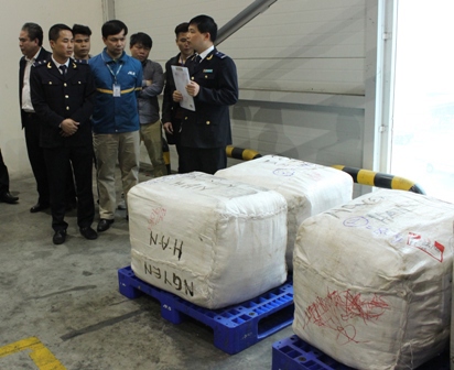 Lực lượng điều tra chống buôn lậu hải quan thực hiện khám xét lô hàng nhập lậu tại kho hàng sân bay Nội Bài. Nguồn: PV.