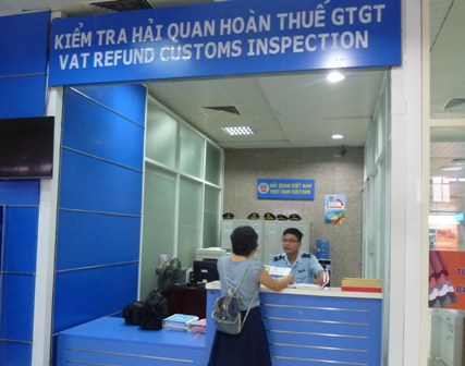 Cán bộ Hải quan sân bay Cam Ranh hướng dẫn hành khách thủ tục hoàn thuế GTGT. Nguồn: PV.