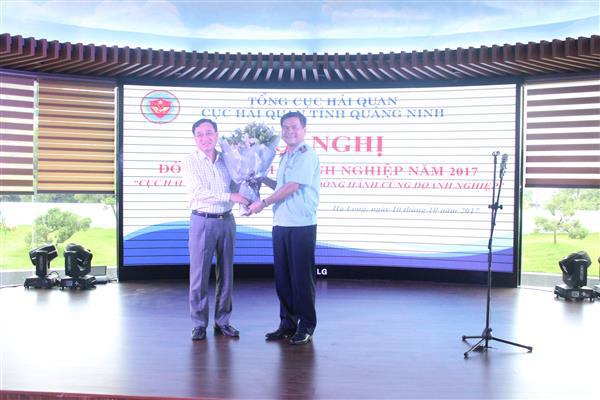 Cục trưởng Cục Hải quan Quảng Ninh Bùi Văn Khắng (bên phải) tặng hoa cho đại diện công đồng doanh nghiệp. 