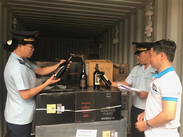 Công chức hải quan cảng Sài Gòn khu vực 4 kiểm tra rượu nhập khẩu. Nguồn: PV.