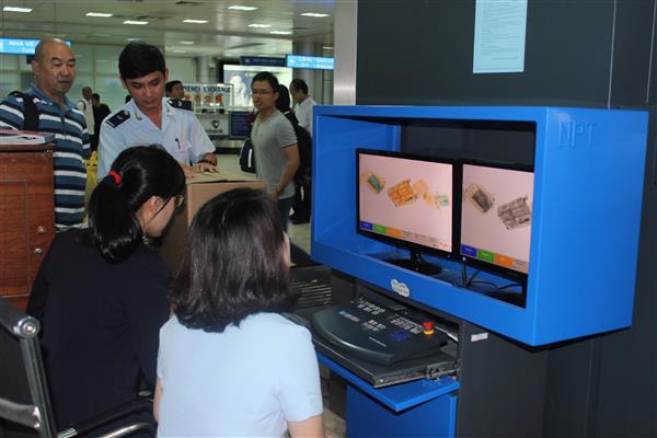 Công chức Chi cục Hải quan cửa khẩu sân bay quốc tế Cam Ranh kiểm tra hành lý qua máy soi. Nguồn: PV.