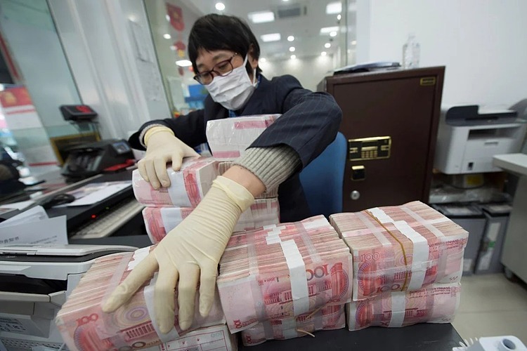  Nhân viên ngân hàng tại Trung Quốc đeo khẩu trang và găng tay khi tiếp xúc với tiền mặt. Ảnh: Reuters 
