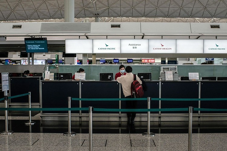  Nhân viên của Cathay Pacific nói chuyện với một hành khách tại sân bay quốc tế Hong Kong vào tháng 2/2020. Ảnh: Bloomberg 