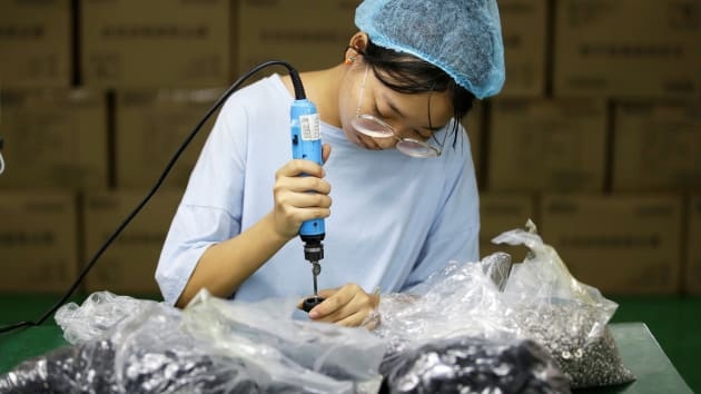 Một nhân viên làm việc trên dây chuyền của nhà máy sản xuất robot hút bụi Matsutek tại Thâm Quyến, Trung Quốc.