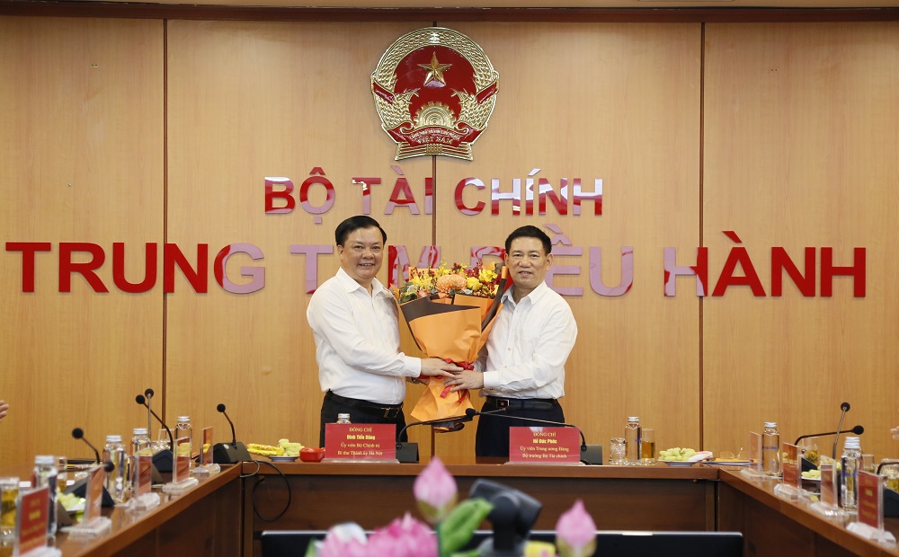 Bộ trưởng Bộ Tài chính Hồ Đức Phớc tặng hoa Bí thư Thành ủy Hà Nội Đinh Tiến Dũng.