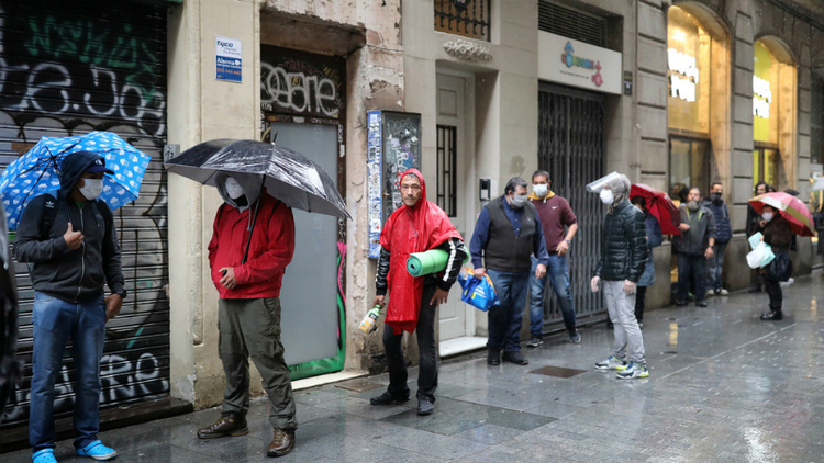 Dòng người xếp hàng chờ nhận các gói thực phẩm miễn phí bên ngoài một nhà thờ tại Santa Anna, ở Barcelona, Tây Ban Nha hôm 21/4. Ảnh: Reuters.
