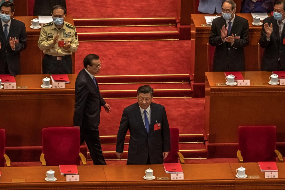 Chủ tịch Trung Quốc Tập Cần Bình (đứng) và Thủ tướng Trung Quốc Lý Khắc Cường (đang đi) tại Quốc hội Trung Quốc. Ảnh EPA-EFE