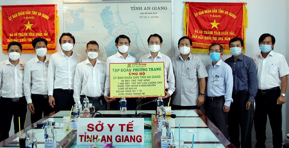 Đại diện Tập đoàn Phương Trang trao tặng bảng tượng trưng thiết bị y tế phòng chống dịch cho lãnh đạo Sở Y tế An Giang. 