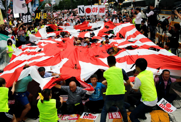  Người dân Hàn Quốc xé Húc Nhật kỳ trong một cuộc biểu tình phản đối Nhật Bản trước lãnh sự quán Nhật tại Seoul vào ngày 20/7/2019 - Ảnh: Reuters