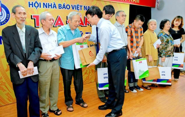 Phó Chủ tịch Thường trực Hội Nhà báo Việt Nam Hồ Quang Lợi trao tặng nhiều phần quà đại diện một số thân nhân nhà báo - liệt sĩ và nhà báo - thương binh có mặt tại buổi Tọa đàm. Nguồn: internet
