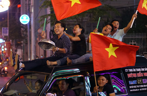  Người hâm mộ bóng đá Việt Nam xuống đường ăn mừng chiến thắng của đội U23 vào tối 23/1. Ảnh: Nguyệt Triều.