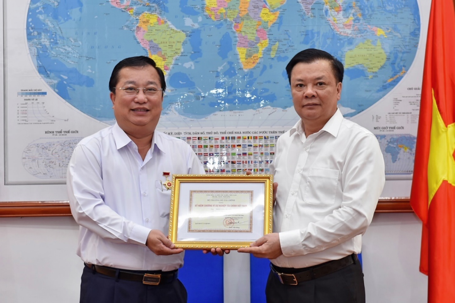 Bộ trưởng Bộ Tài chính (biên phải) trao tặng Kỷ niệm chương cho Chủ tịch UBND tỉnh Sóc Trăng. Nguồn: MOF