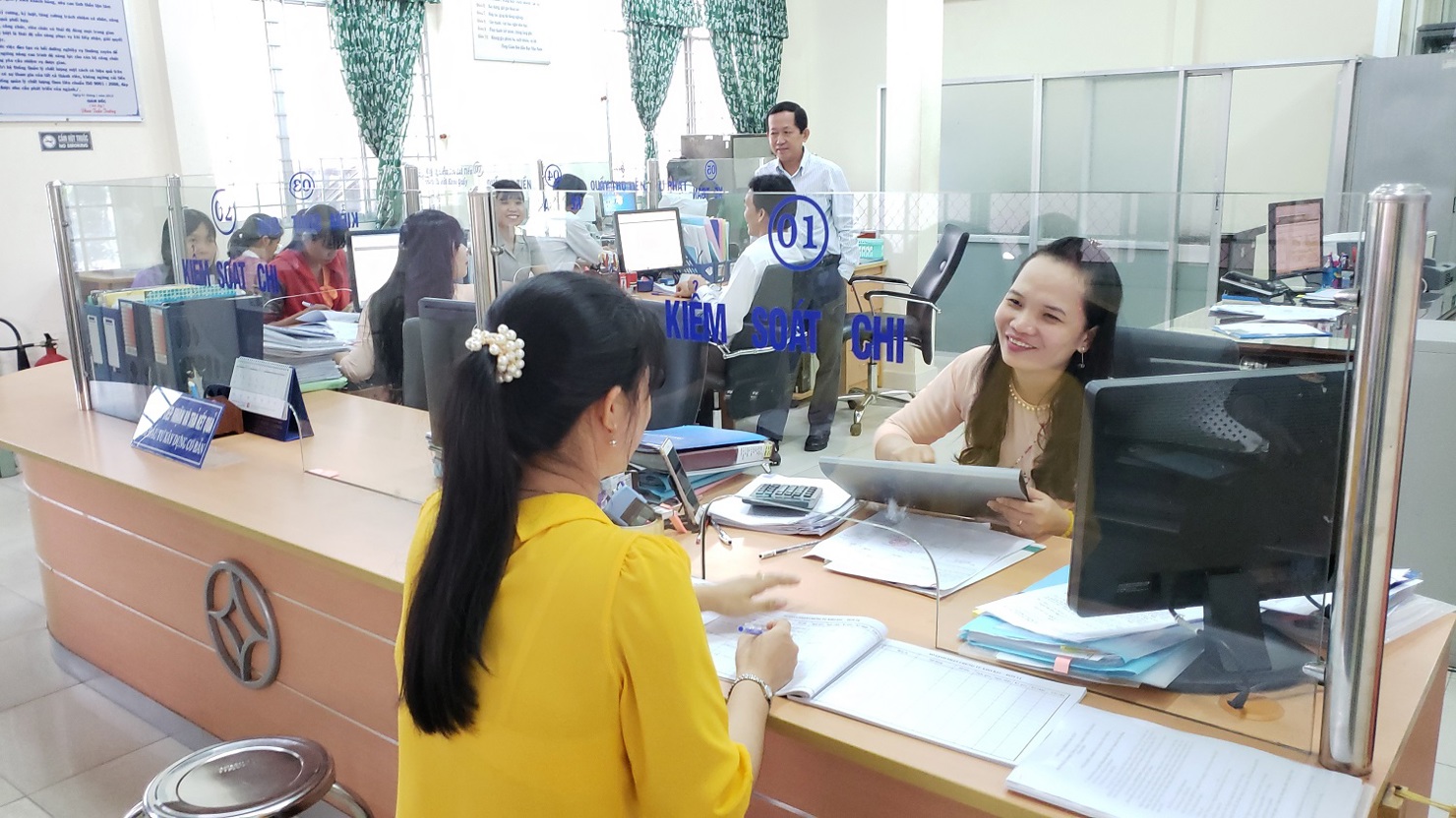 Chị Lê Thị Nguyệt Nga, giao dịch viên KBNN Tân Phú Đông (KBNN Tiền Giang) đang hướng dẫn khách hàng làm thủ tục quyết toán