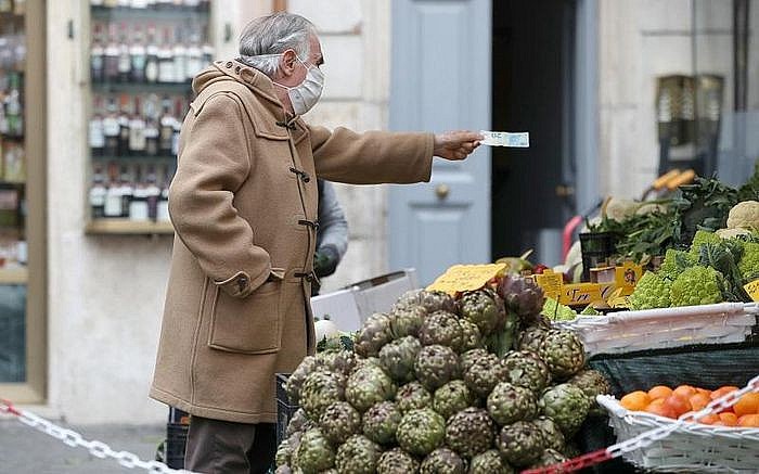 Người dân mua hàng hóa tại một khu chợ ngoài trời ở Italia