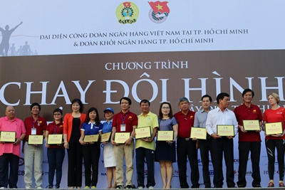 Trưởng VPĐDKVMN - ông Trần Ngọc Hải (áo đỏ thứ 2 bên phải) đại diện Agribank nhận kỉ niệm chương từ Ban tổ chức.