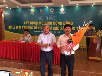 Thứ trưởng Bộ Tài Nguyên và Môi trường Nguyễn Linh Ngọc trao Kỷ niệm chương và hoa cho đại diện Agribank - ông Trương Ngọc Anh, Phó Tổng Giám đốc.