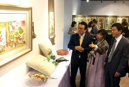 Nghệ nhân tranh dân gian Hàn Quốc Jung Seung Hee giới thiệu một tác phẩm với Tân Đại sứ Hàn Quốc tại Việt Nam Lee Hyuk (bên phải).
