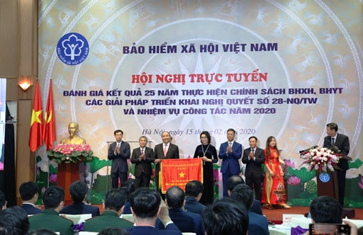 Thủ tướng Nguyễn Xuân Phúc trao tặng Cờ Thi đua của Chính phủ cho BHXH Việt Nam tại Hội nghị trực tuyến toàn quốc “Đánh giá kết quả 25 năm thực hiện chính sách BHXH, BHYT; các giải pháp triển khai Nghị quyết số 28-NQ/TW và nhiệm vụ công tác năm 2020”.