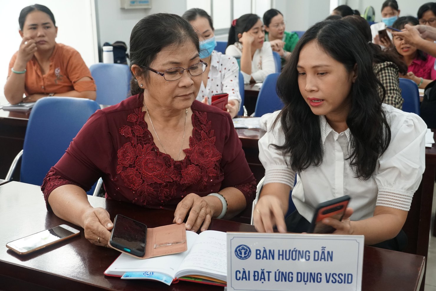 Cán bộ, viên chức BHXH TP.Hồ Chí Minh tư vấn, hướng dẫn người dân sử dụng ứng dụng VssID - BHXH số.