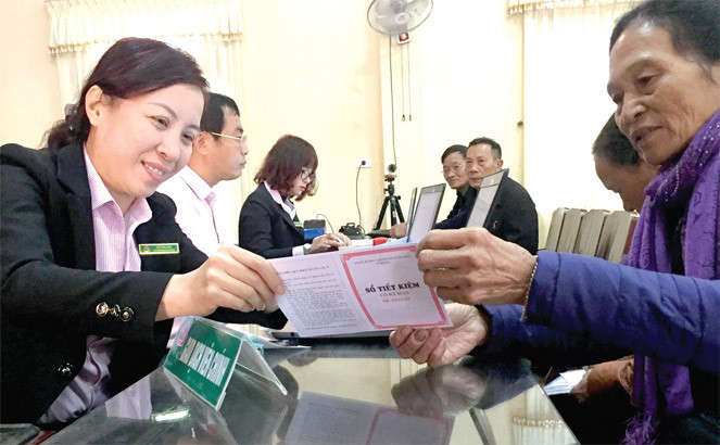 Cán bộ tín dụng Ngân hàng Chính sách Xã hội huyện Vũ Thư hướng dẫn bà con gửi tiết kiệm tại Điểm giao dịch xã Tân Hòa. Nguồn: internet.