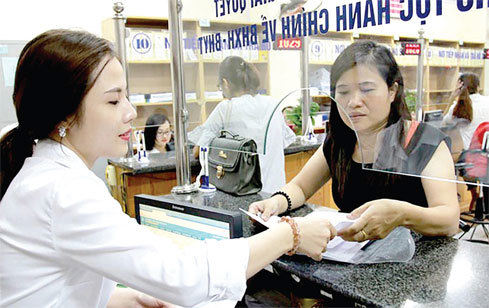 Hướng dẫn người dân làm thủ tục tại Bảo hiểm xã hội thành phố Hà Nội. Nguồn: Internet