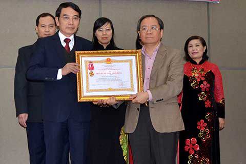 Thứ trưởng Bộ Tài chính Đỗ Hoàng Anh Tuấn (bên phải) thừa ủy quyền của Chủ tịch nước trao tặng Huân chương Lao động Hạng Nhất cho Chi cục Thuế huyện Gia Lâm.