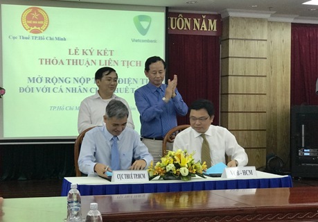 Lãnh đạo Cục thuế TP. Hồ Chí Minh và Vietcombank Chi nhánh TP. Hồ Chí Minh thực hiện nghi thức ký kết. Ảnh Đ.Doãn