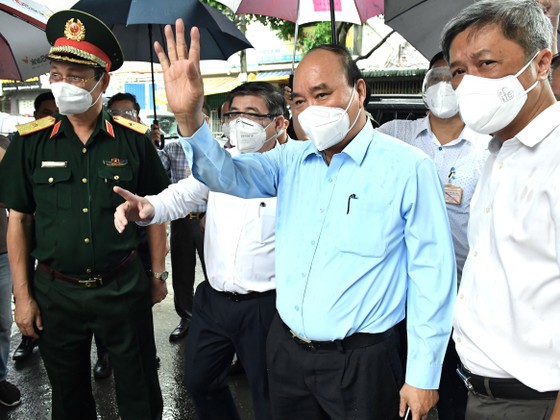 Chủ tịch nước Nguyễn Xuân Phúc thăm hỏi người dân khu vực phong tỏa ở huyện Hóc Môn. Ảnh: Báo SGGP
