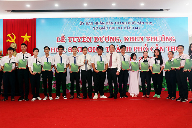 Ông Lê Quang Mạnh Chủ tịch UBND TP. Cần Thơ (thứ 7 từ trái sang) và ông Trần Long Giang – Giám đốc Vietcombank Cần Thơ (thứ 9 từ trái sang) trao học bổng cho các em học sinh