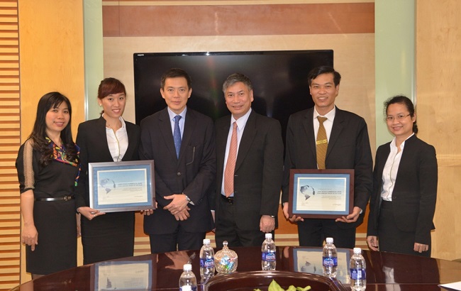 Phó Tổng giám đốc Nguyễn Danh Lương (thứ 3 từ phải sang) cùng lãnh đạo các phòng/trung tâm của Vietcombank nhận giấy Chứng nhận Ngân hàng xuất sắc xử lý thanh toán tự động điện MT103, MT202 năm 2015