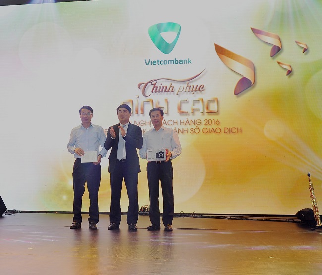 Ông Nghiêm Xuân Thành – Chủ tịch HĐQT (đứng giữa) tặng quà cho các khách hàng