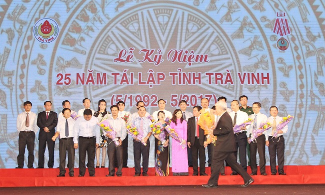 Ông Nghiêm Xuân Thành – Chủ tịch HĐQT Vietcombank (hàng sau, thứ 6 từ trái sang) nhận hoa vinh danh của lãnh đạo tỉnh Trà Vinh đối với những đóng góp của Vietcombank cho công tác an sinh xã hội trên địa bàn Tỉnh