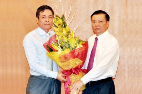 Bộ trưởng Đinh Tiến Dũng tặng hoa chúc mừng tân Cục trưởng Cục Quản lý giám sát Bảo hiểm Phùng Ngọc Khánh. Nguồn: mof.gov.vn